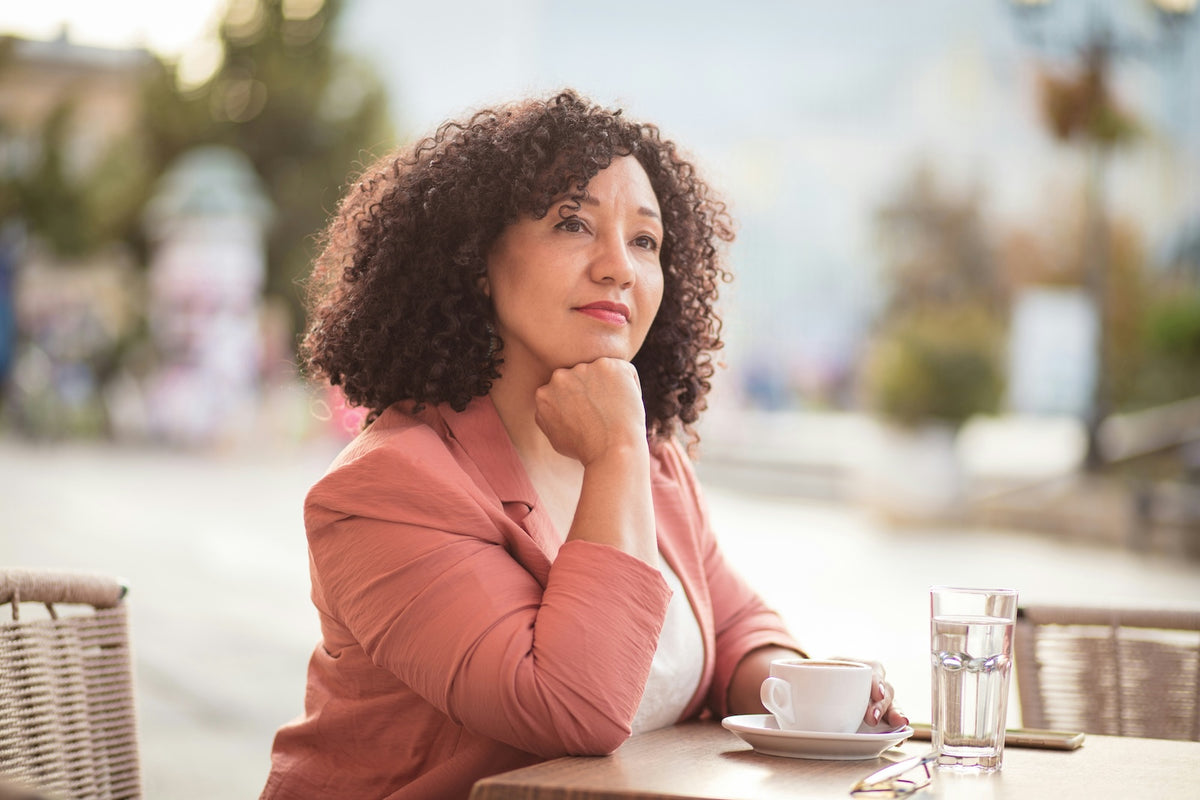 Woman with coffee at an outdoor café — life on a Virgo-Meds program